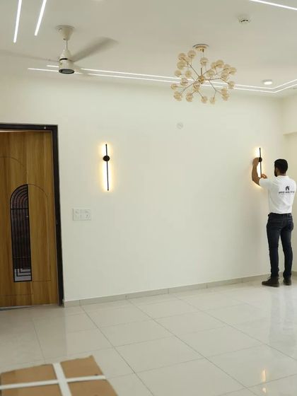 Our team member installing wall lights in a living room, ensuring every detail is perfect.