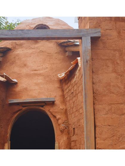 A glimpse of the mud-plastered dome at Cheerville. The rich, earthy tones of the structure are a direct result of using natural, biodegradable building materials and traditional methods.