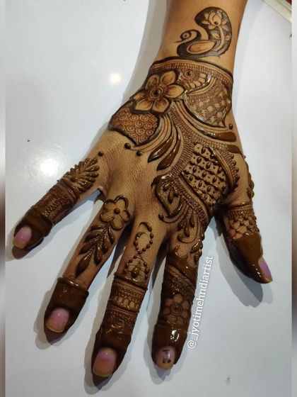 A stylish Indo-Arabic design featuring a peacock on the wrist. The pattern flows down the hand, creating a modern and artistic look.