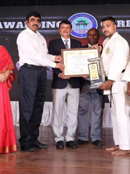 The journey is a shared one. A student and his parents receive his black belt award, a testament to the family support that is crucial for success.
