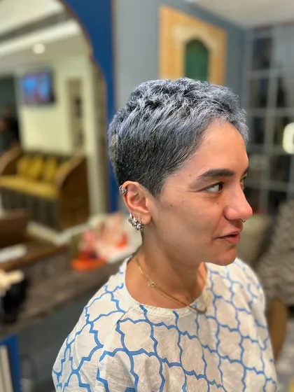 The side profile of this ash-blue crop cut shows how the style is tailored to the head shape. It's a modern, confident look that makes a statement.