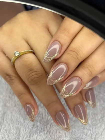 A close-up of the elegant nude and gold line art design, framed by a ring light.