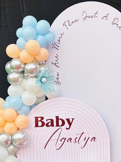 A detail shot of the left side of the backdrop, featuring the personalized "Baby Agastya" sign and the quote "you are more than just a dream".