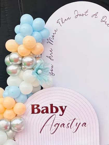 A detail shot of the left side of the backdrop, featuring the personalized "Baby Agastya" sign and the quote "you are more than just a dream".