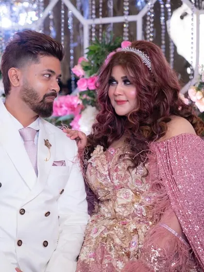 Hey, Husband. A candid, happy moment with my partner against the beautiful floral backdrop of our reception.