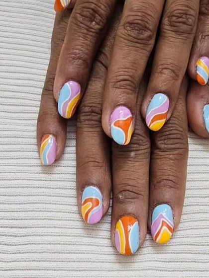 Feeling groovy with these retro-inspired wavy nails. The combination of pastel and orange stripes creates a fun, psychedelic pattern that’s full of personality.