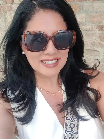 A sunny selfie in Venice, accessorizing with oversized sunglasses and a simple pearl necklace.