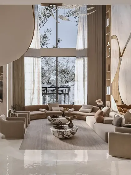 This angle captures the impressive floor-to-ceiling windows that flood the reception area with natural light. The curved sectional sofa follows the organic lines of the space, enhancing the feeling of openness and connection to the outdoors.