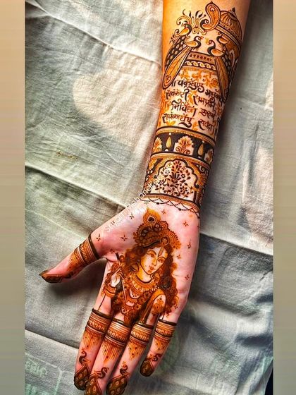 A portrait of Lord Krishna on the palm, complemented by intricate patterns and mantras on the arm.