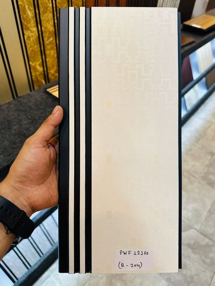 A subtle and elegant off-white fluted panel with a faint geometric pattern and black grooves. It adds texture without overwhelming the space.