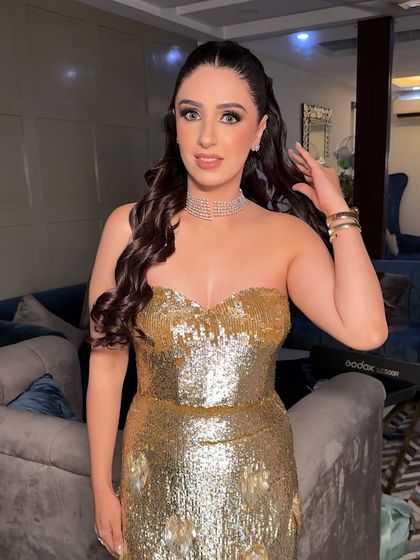 A close-up showing her happiness with the final look. The makeup enhances her features beautifully, and the soft waves frame her face perfectly.