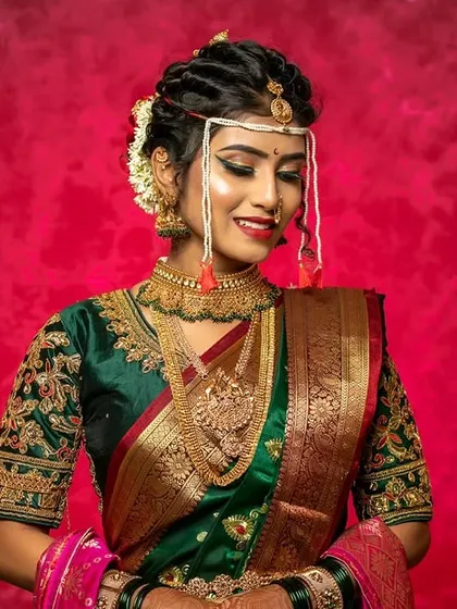 A close-up of a stunning Maharashtrian bridal look. The focus here is on the intricate eye makeup and the traditional 'mundavalya' that frames the face beautifully.