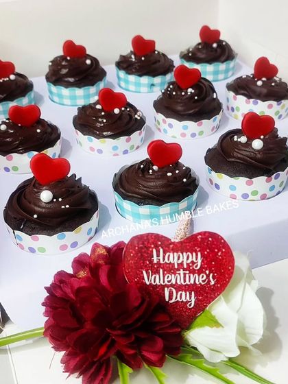 A box of my special Valentine's Day cupcakes. These are rich chocolate cupcakes topped with chocolate frosting and a small red heart, presented in a box with a 'Happy Valentine's Day' sign.
