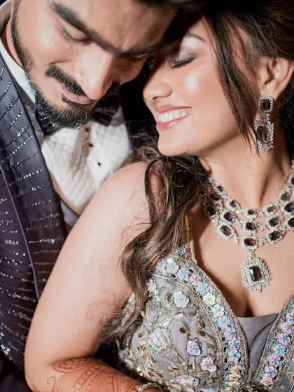An intimate and romantic close-up. This shot captures the bride's joyful smile and the sparkling details of her reception jewelry and outfit.