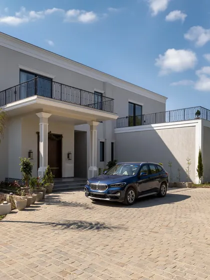 The arrival experience is the first chapter of a home's story. The paved driveway and stately entrance of this villa create a sense of occasion, welcoming residents and guests into a world of bespoke design.
