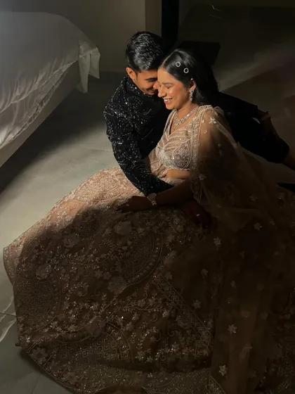 A romantic, candid moment from the sangeet night photoshoot. Her makeup and hair look flawless even in the soft, dim lighting.