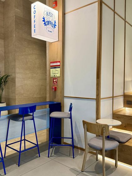 We integrated Beanly's signature electric blue into the furniture, using sleek metal sections for the high-top counter and chairs. This adds a vibrant pop of color while maintaining a visually light and modern aesthetic.