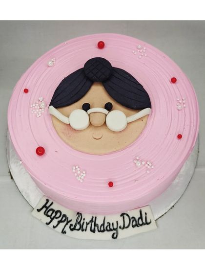 A special cake for a grandmother's birthday. This mixed fruit cake features a cute, handmade fondant face of a "Dadi" with glasses.