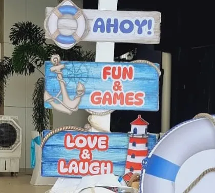 "Ahoy!" This nautical-themed signpost points the way to fun, games, love, and laughter at a sailor party.
