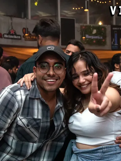 Friends enjoying the night at Sarjapur Social. The peace sign says it all: just good vibes and fun times.