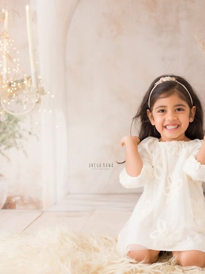 A joyful solo portrait of an older sister in a dreamy, rustic studio setting. Her bright smile is the focus of this lovely shot.