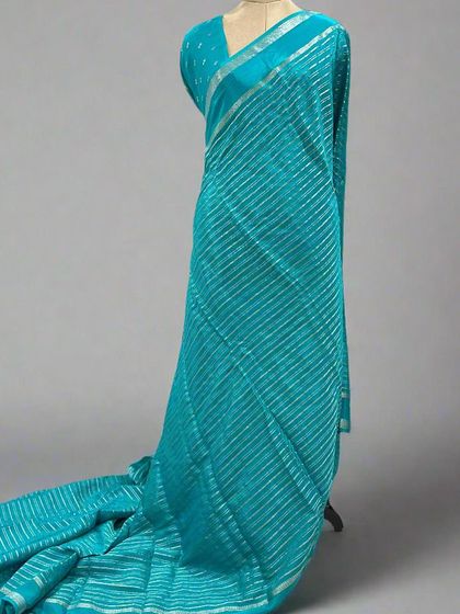 A mannequin draped in a teal blue saree with silver stripes.