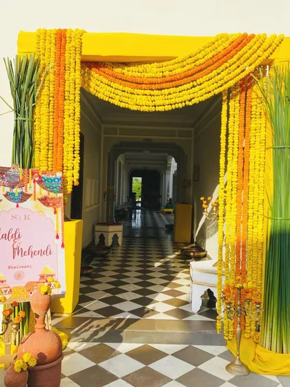 The energy of a Haldi ceremony starts at the entrance. I used bold yellow framing and dense strings of traditional marigolds to create a vibrant and joyful welcome that sets the tone for the fun-filled event ahead.