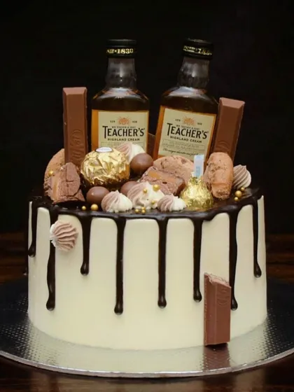 This is my signature loaded drip cake, perfect for a milestone birthday. It features a rich chocolate drip, and is topped with miniature whiskey bottles, Ferrero Rocher, KitKats, and other chocolatey treats.