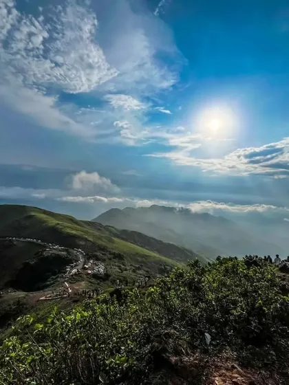 A breathtaking view from a peak in Chikmagalur, with the sun breaking through the clouds.