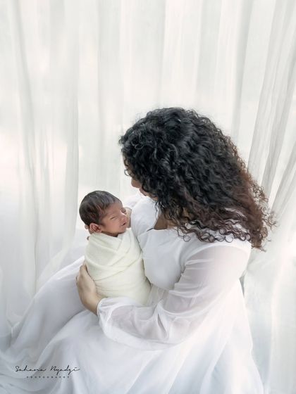 A mother's first moments with her newborn are pure magic. This portrait, set against a soft, bright window light, captures the quiet bond and tenderness between a mom and her new baby.