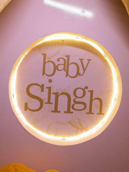 A custom light-up sign for "Baby Singh." This personalized element adds a warm glow and serves as a beautiful focal point for the baby shower decor.