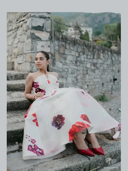 A beautiful portrait of the bride sitting on stone steps in Italy. Her floral dress and elegant pose create a look that is both fashionable and timeless.