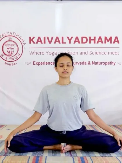 A practitioner is seated in Baddha Konasana (Bound Angle Pose), a hip-opening posture that is beneficial for the pelvic region. This pose is often used in preparation for meditation.