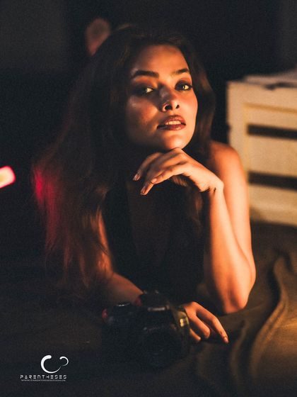 A classic and confident portrait. The camera prop and her direct gaze create a powerful image of a creative soul.