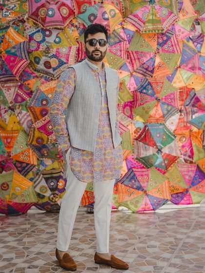 Adi Bhatia radiates color in this festive ensemble. I paired a vibrant printed kurta with a simple, structured grey bundi for a balanced and stylish Mehendi look.