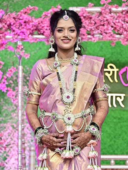 A full-length view of this stunning baby shower look. The makeup, hair, and floral jewelry come together perfectly with the shimmering saree, creating a memorable and traditional ensemble.