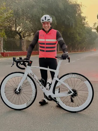 A rider proudly displaying his white Pinarello Dogma, a top-of-the-line racing bike.