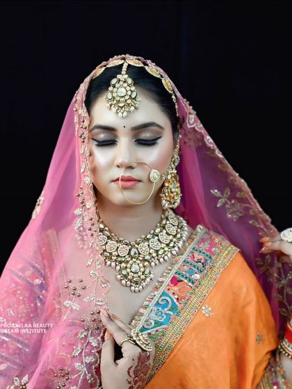 The sheer pink dupatta adds a layer of softness to this vibrant look. The makeup remains visible and radiant, perfect for photos with and without a veil.