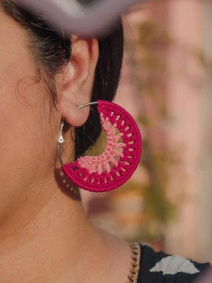 A close-up shot of the 'Vibha' pink hoops, captured through a heart-shaped mirror. These are perfect for adding a touch of romance to your look.