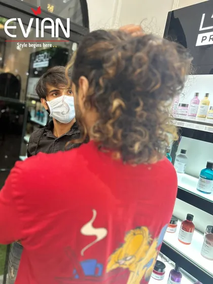 A consultation in progress. Here I am discussing highlight options with a client who has long, curly hair, ensuring we choose a color that will enhance his natural texture.
