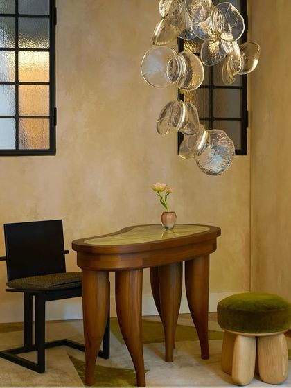 A small installation of the Bocci 141 series adds an artistic touch to a minimalist corner with an Eames chair and Noguchi table.