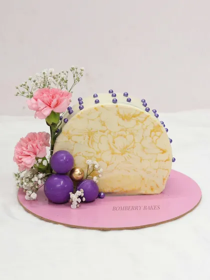 A modern arch cake with floral decorations, created by a student.