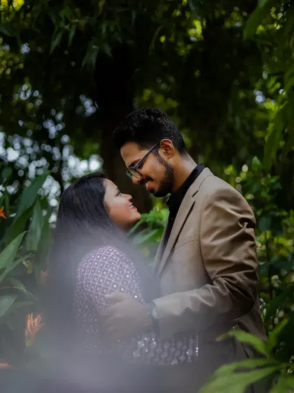 A romantic portrait of the couple surrounded by lush greenery. The natural setting creates a beautiful and serene atmosphere for a pre-wedding shoot.