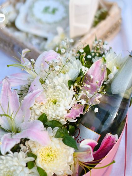 A close-up of the proposal details. We arranged a bottle of sparkling wine within a beautiful bouquet of lilies and chrysanthemums, ready for the couple to celebrate their special moment.