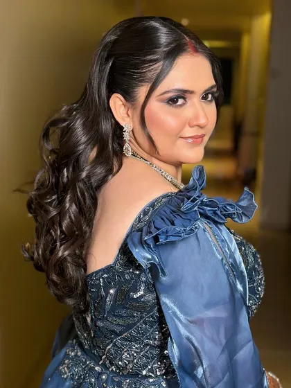 A look at the elegant hairstyle from the back. The soft, voluminous curls add a touch of Hollywood glamour to her reception look.