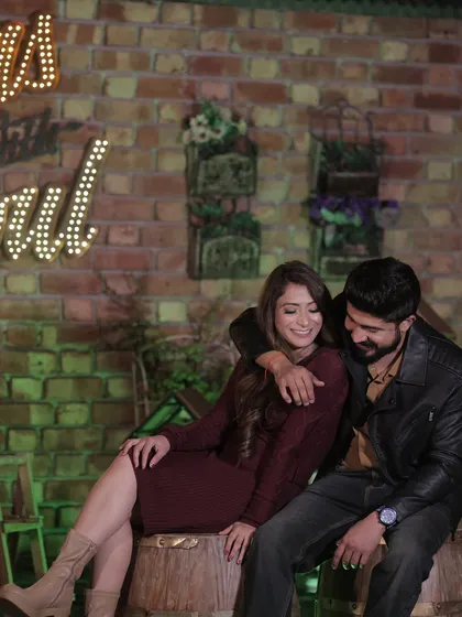 This couple's pre-wedding shoot has a rustic, cozy vibe. The makeup is soft and warm, complementing the earthy tones of the setting and outfits.