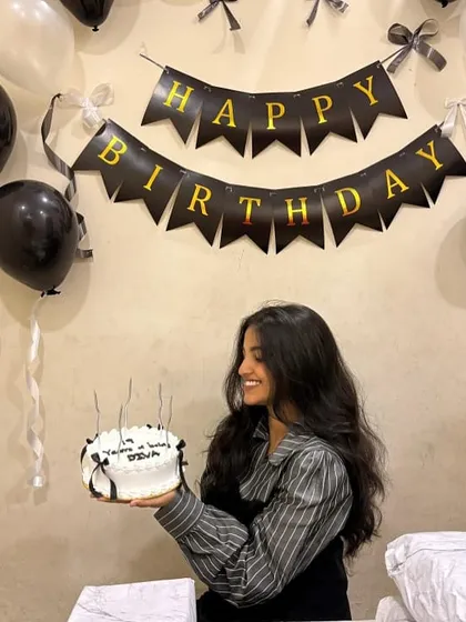 A happy client with her classic vintage cake, decorated with simple black bows. It's a chic and timeless design that's perfect for any stylish celebration.