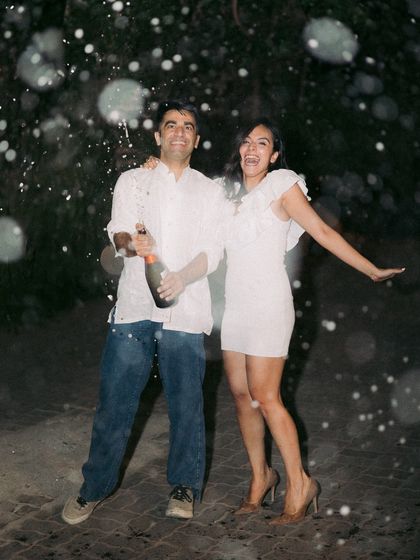 A moment of pure celebration as a newly engaged couple pops a bottle of champagne.