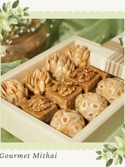 A box of our Gourmet Mithai, featuring contemporary twists on classics. This selection includes Hazelnut Laddoos and Walnut Caramel bites, blending traditional techniques with modern flavors.