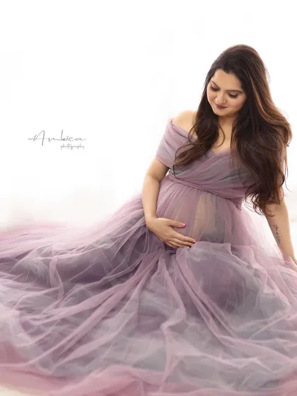 Sometimes, a simple, soft moment is the most powerful. This off-the-shoulder lavender tulle gown is all about gentle romance, perfect for capturing the quiet joy and anticipation of motherhood in a studio setting.